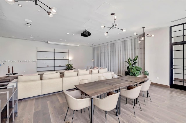 dining room with wood-type flooring and an inviting chandelier