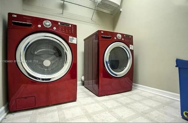 laundry area with washer and dryer and light tile patterned floors