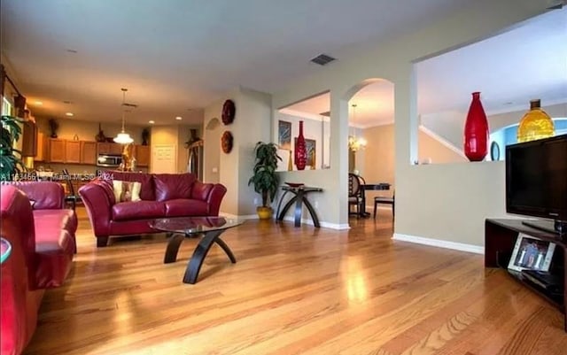 living room with light hardwood / wood-style flooring and a chandelier