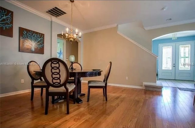 dining space featuring a notable chandelier, wood-type flooring, and crown molding