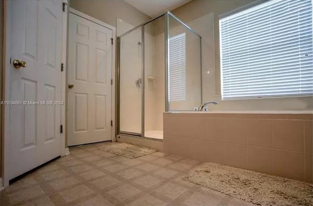 bathroom with an enclosed shower and tile patterned floors