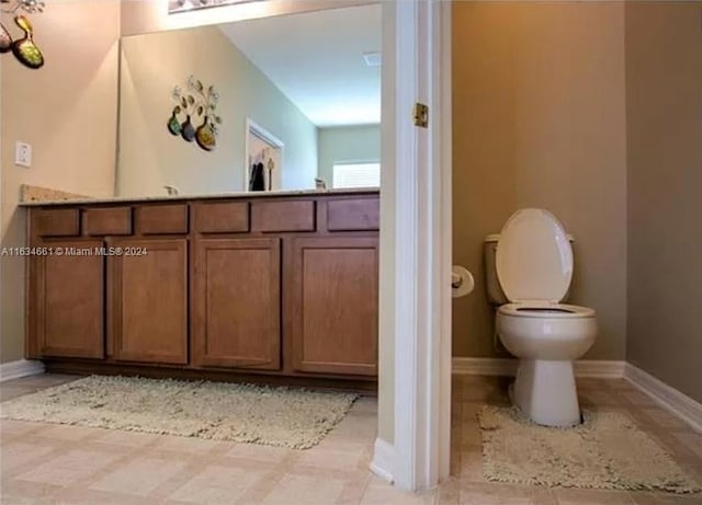 bathroom with vanity, tile patterned flooring, and toilet