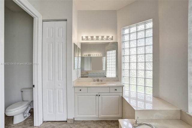 bathroom featuring vanity, toilet, tile patterned flooring, and a tub