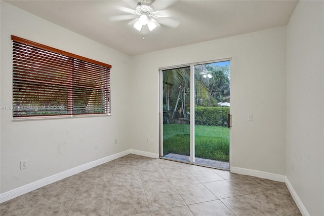 tiled spare room featuring ceiling fan