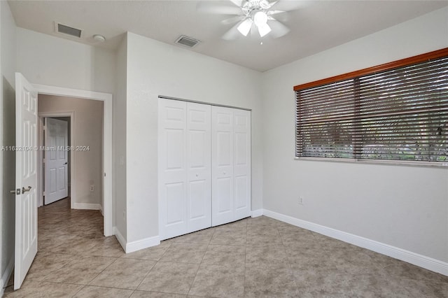 unfurnished bedroom featuring light tile patterned floors, a closet, and ceiling fan