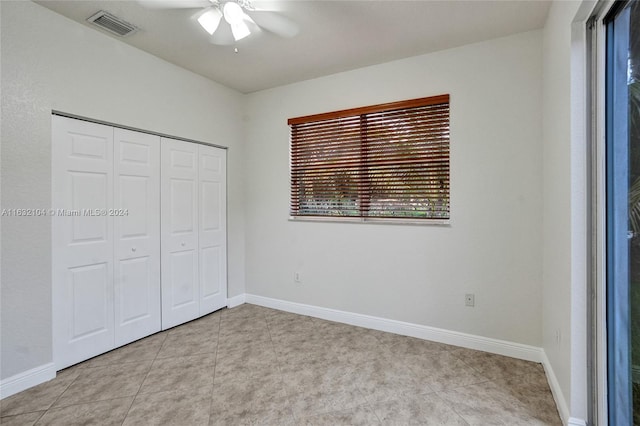 unfurnished bedroom with ceiling fan, a closet, and light tile patterned floors