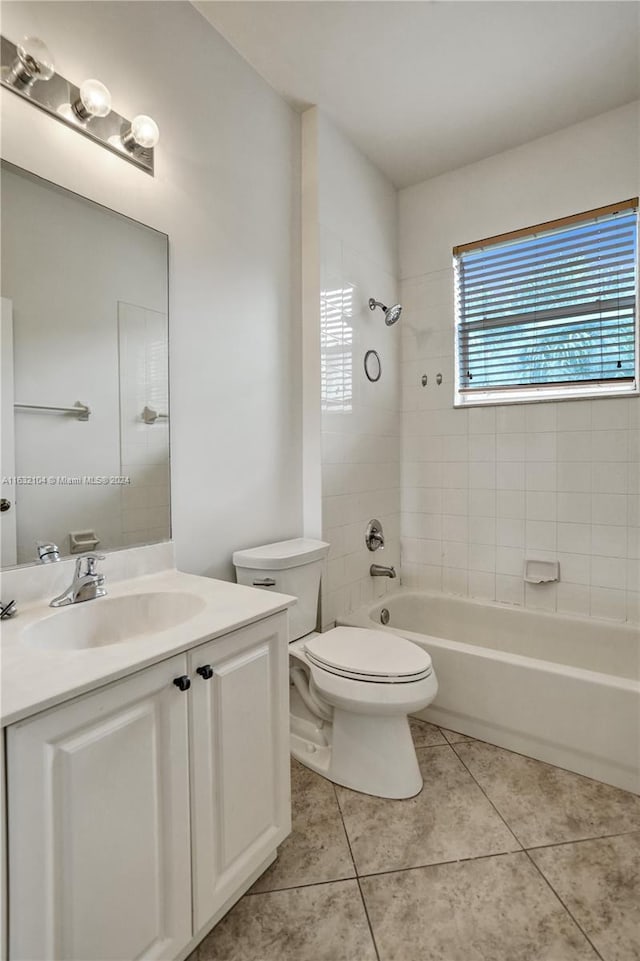 full bathroom with tiled shower / bath, vanity, toilet, and tile patterned flooring