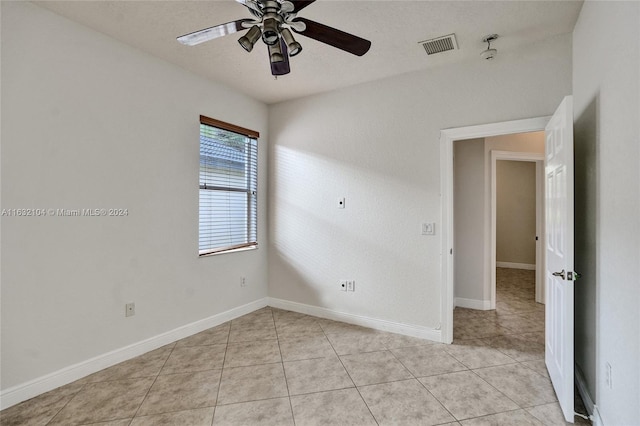 tiled spare room featuring a textured ceiling and ceiling fan