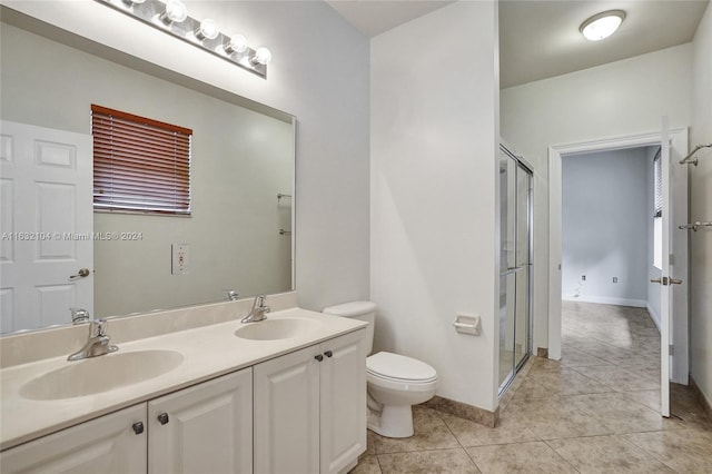 bathroom with tile patterned flooring, vanity, toilet, and walk in shower