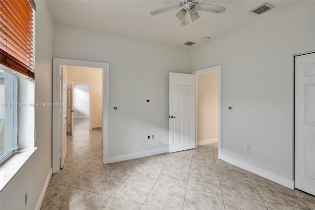 unfurnished bedroom with multiple windows, light tile patterned floors, and ceiling fan