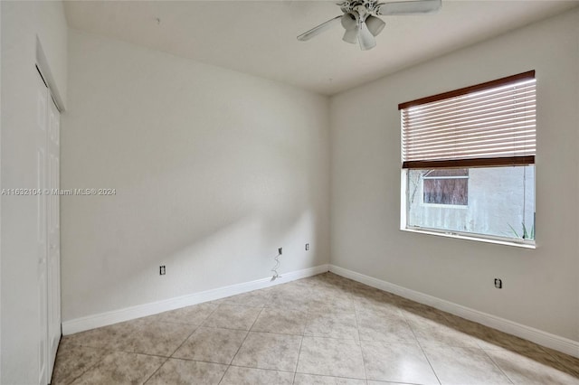 empty room with light tile patterned floors and ceiling fan