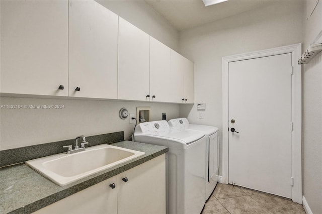 clothes washing area featuring separate washer and dryer, sink, light tile patterned floors, and cabinets