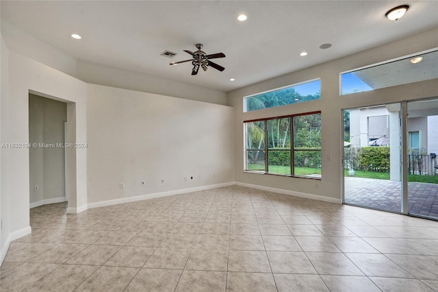 tiled spare room with ceiling fan