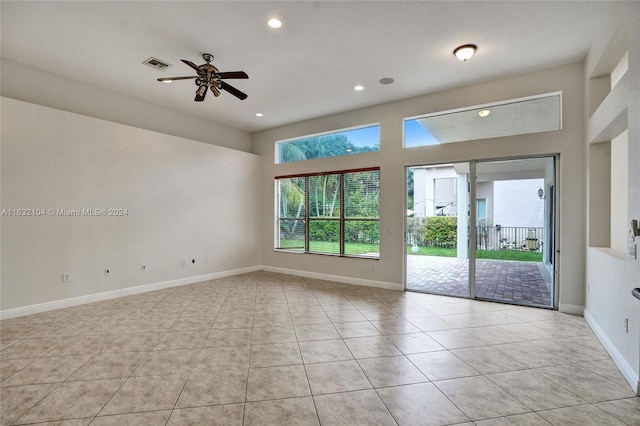 tiled spare room with ceiling fan