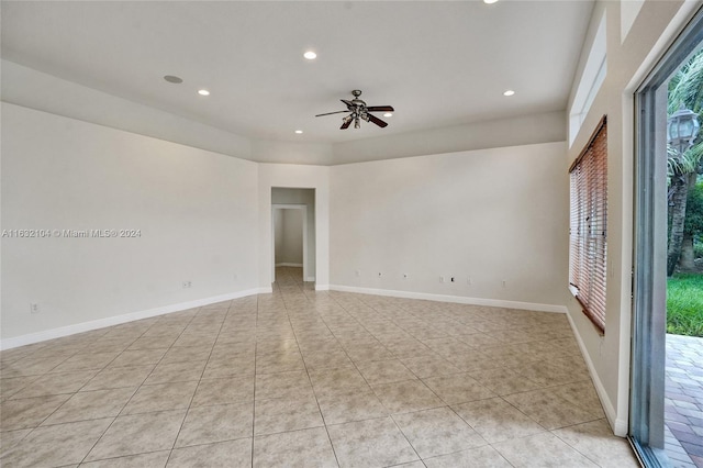 tiled spare room featuring ceiling fan