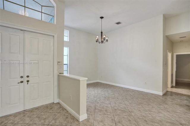 tiled foyer with a notable chandelier