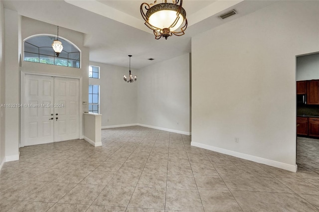 tiled foyer featuring a notable chandelier