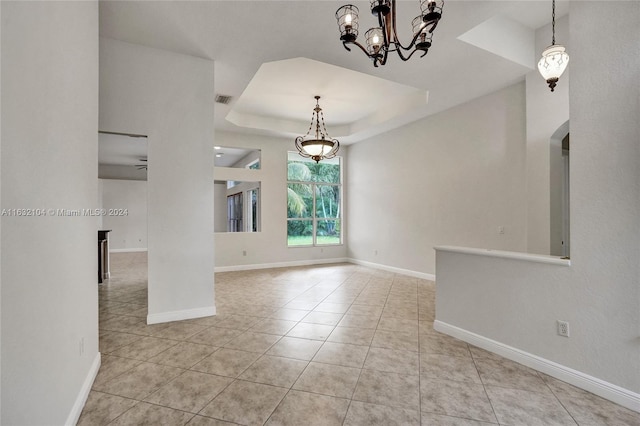 empty room featuring light tile patterned floors and a tray ceiling