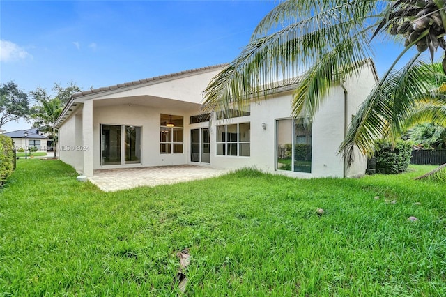 rear view of property featuring a yard and a patio area