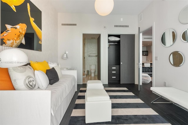 interior space featuring connected bathroom, a closet, and dark hardwood / wood-style floors