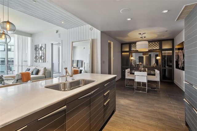 kitchen featuring dark wood-type flooring, sink, and hanging light fixtures