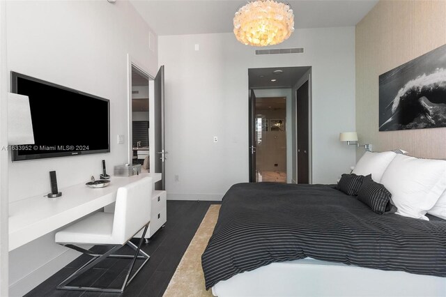 bedroom with a notable chandelier and dark hardwood / wood-style flooring