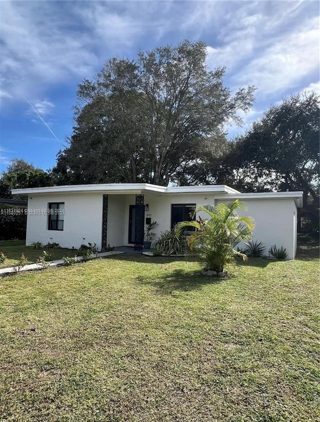 ranch-style home with a front lawn