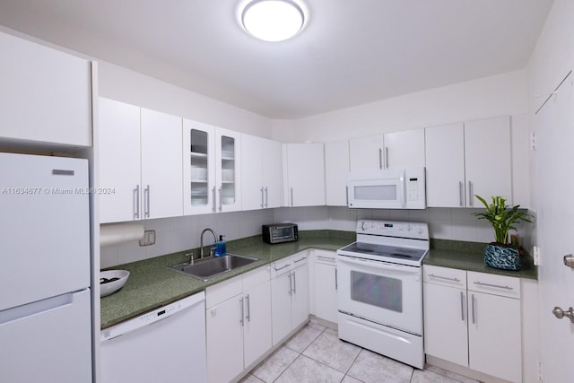 kitchen with white appliances, light tile patterned floors, white cabinets, decorative backsplash, and sink