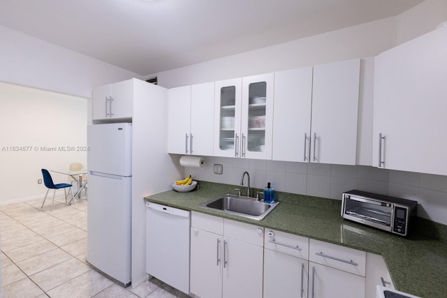 kitchen featuring white appliances, sink, backsplash, light tile patterned floors, and white cabinetry