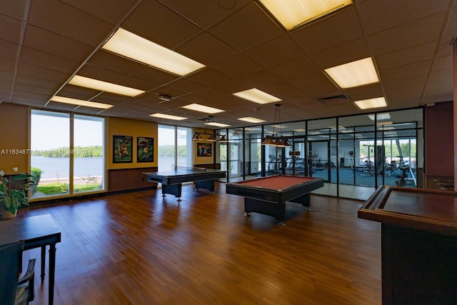 recreation room with a drop ceiling, a water view, pool table, and dark hardwood / wood-style flooring