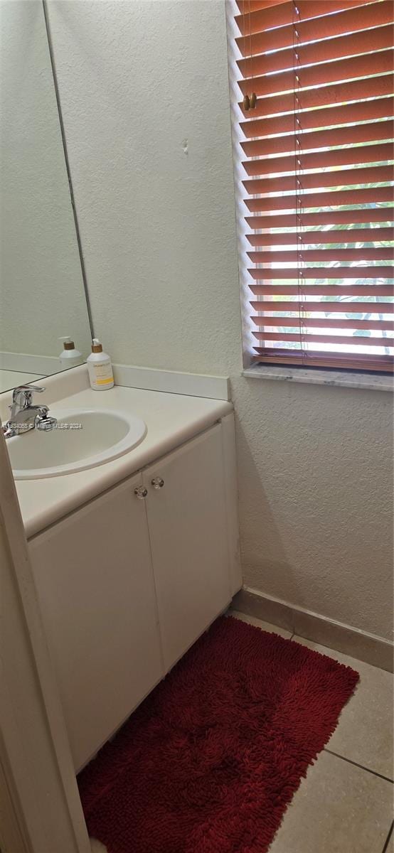 bathroom featuring tile patterned flooring, vanity, and a wealth of natural light