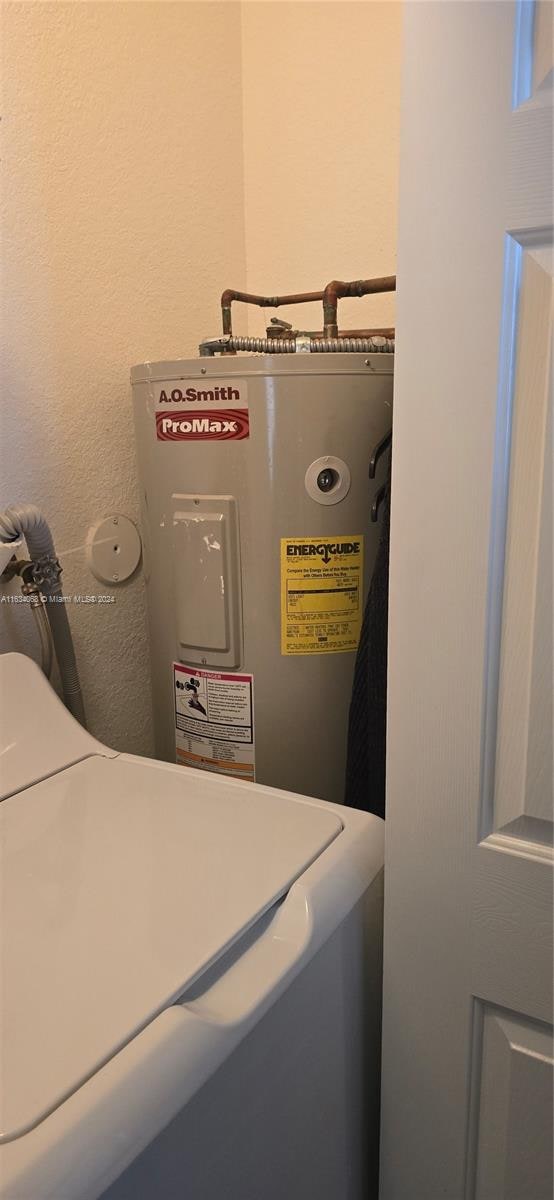 utility room with water heater and washer / dryer