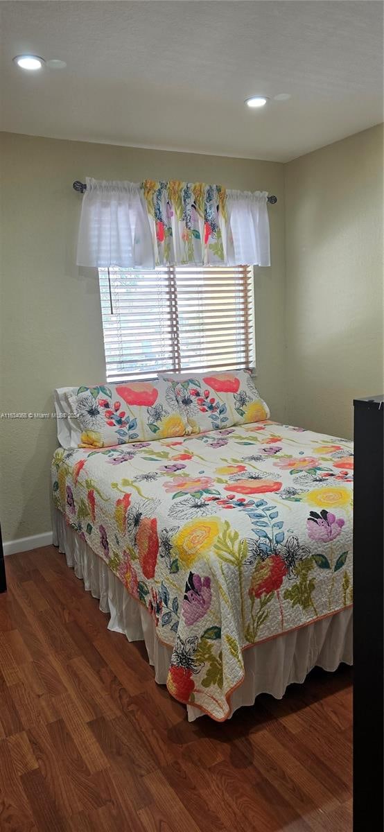 bedroom with multiple windows and hardwood / wood-style floors