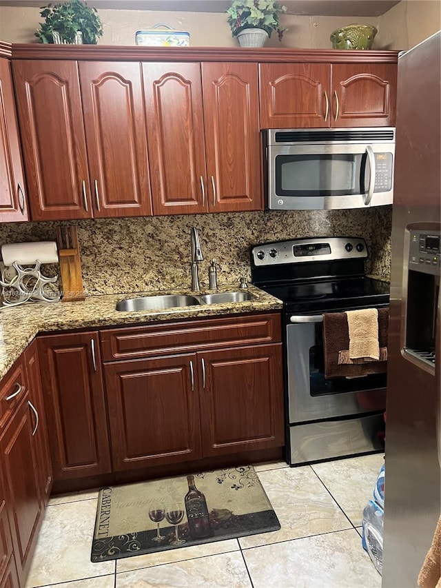 kitchen featuring light stone counters, sink, stainless steel appliances, and tasteful backsplash