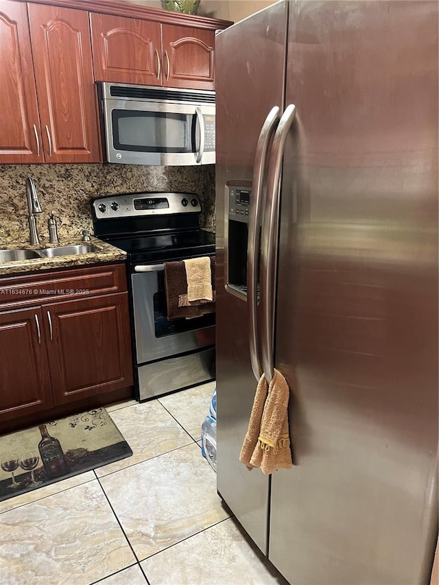 kitchen featuring backsplash, light tile patterned flooring, sink, and stainless steel appliances