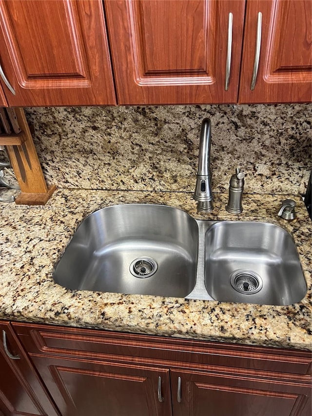 details featuring tasteful backsplash, sink, and stone countertops