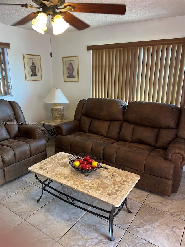 tiled living room with a textured ceiling and ceiling fan