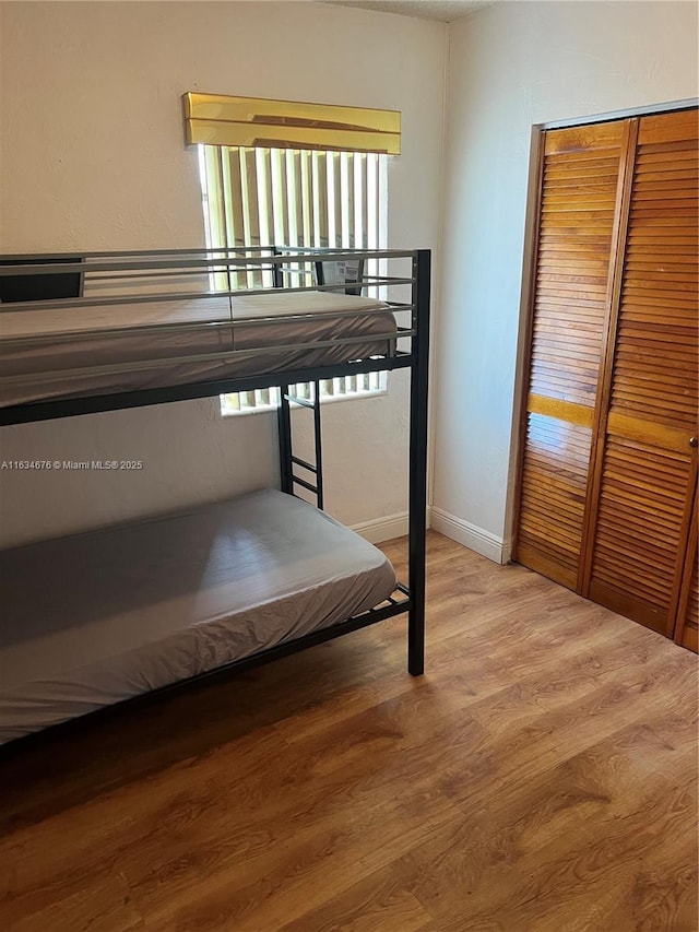 unfurnished bedroom featuring a closet and wood-type flooring