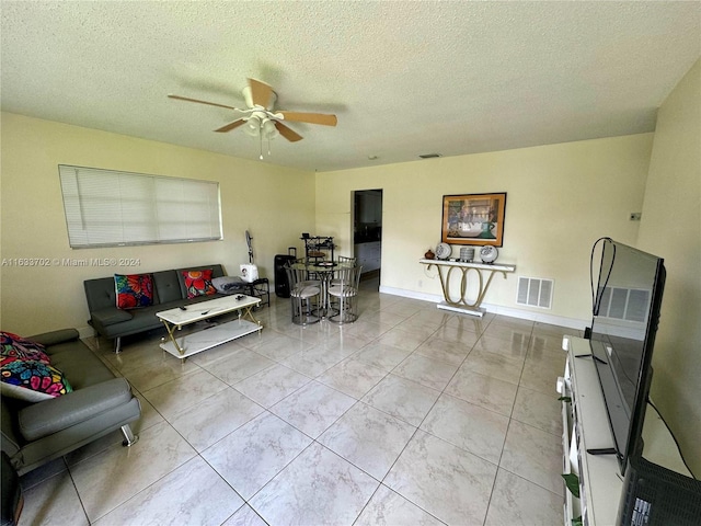 tiled living room featuring a textured ceiling and ceiling fan