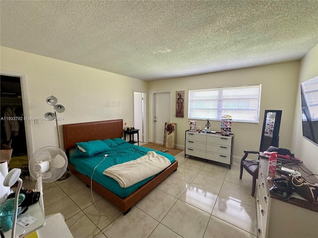 tiled bedroom featuring a closet and a textured ceiling