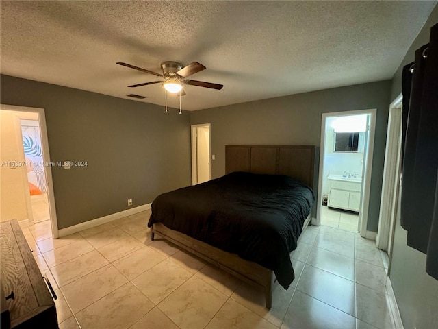 tiled bedroom with ensuite bath, a textured ceiling, and ceiling fan