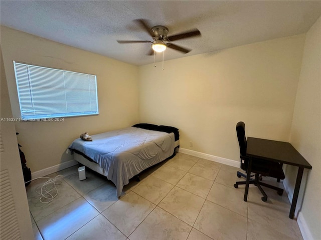 tiled bedroom with a textured ceiling and ceiling fan