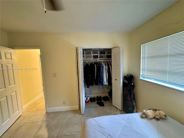 tiled bedroom with a closet