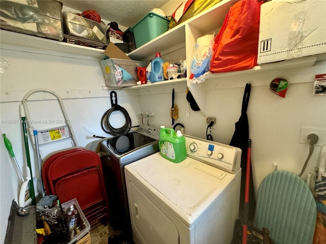 clothes washing area with a textured ceiling and independent washer and dryer