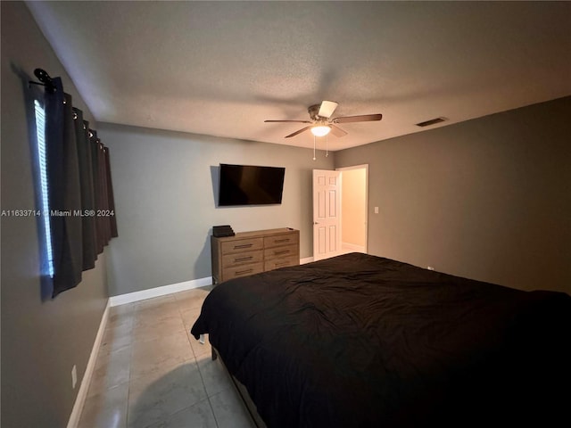 bedroom featuring light tile patterned flooring, a textured ceiling, and ceiling fan