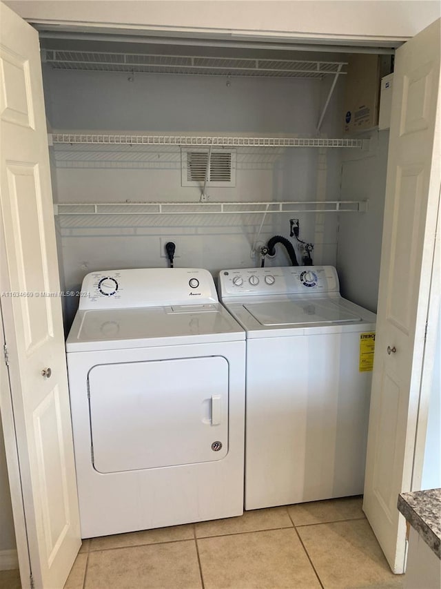 laundry room with light tile patterned floors and washer and dryer