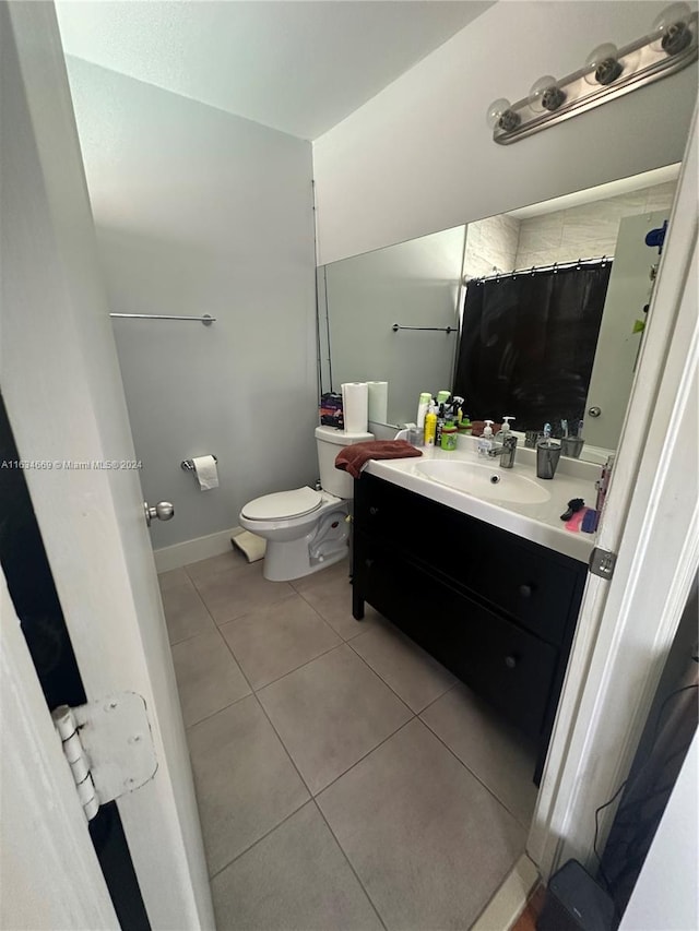 bathroom featuring curtained shower, tile patterned flooring, vanity, and toilet