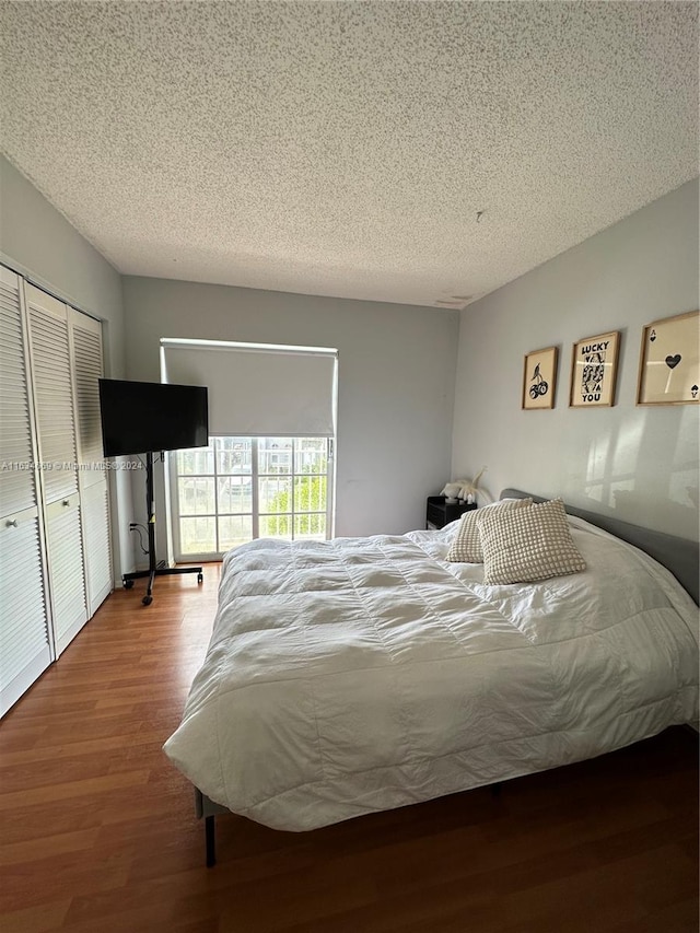 bedroom featuring a textured ceiling, a closet, and hardwood / wood-style floors