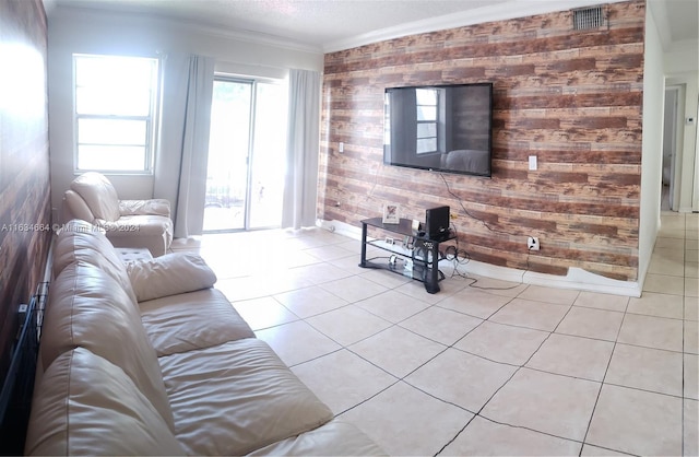 living room with wooden walls, light tile patterned floors, and ornamental molding