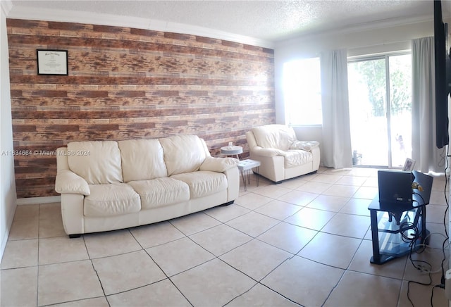 living room featuring wood walls, crown molding, light tile patterned floors, and a textured ceiling